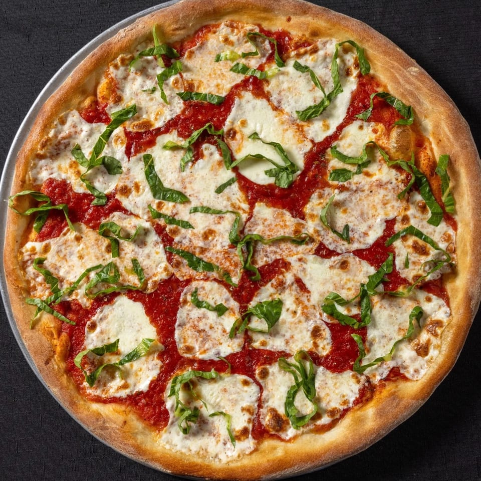 Vinnie's Pizzeria's Margherita pizza, featuring fresh mozzarella, vibrant tomato sauce, and basil on a crispy crust.