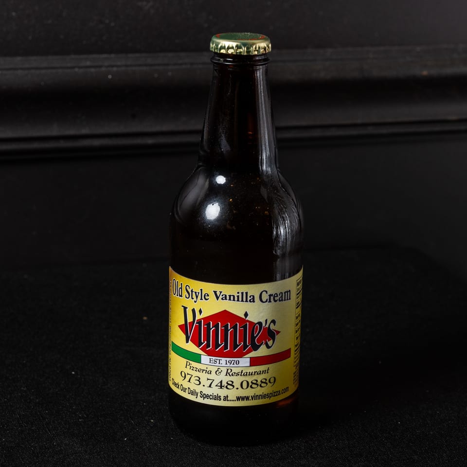 A bottle of Vinnie's Old Style Vanilla Cream soda with a yellow and red label.
