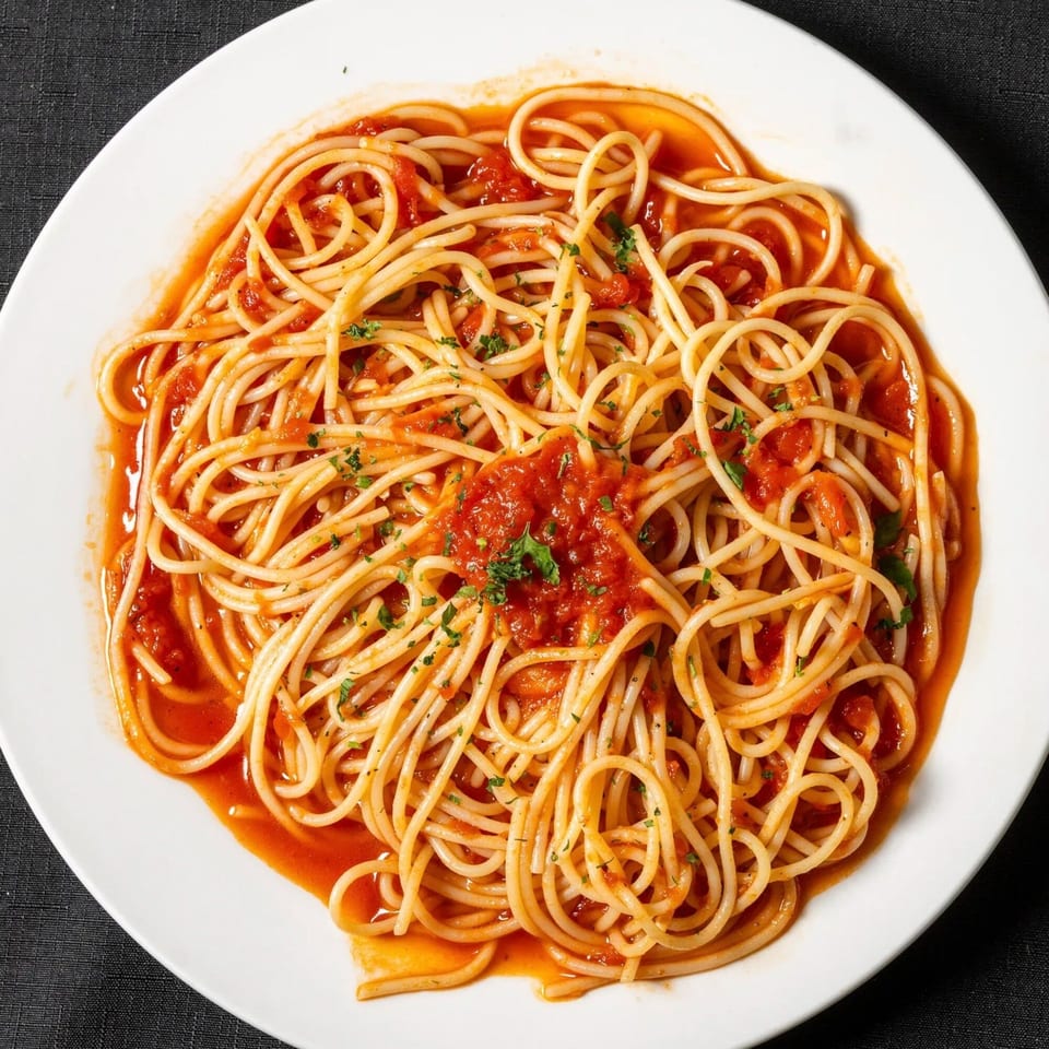 Spaghetti with red tomato sauce and parsley on a white plate at Vinnie's Pizzeria.