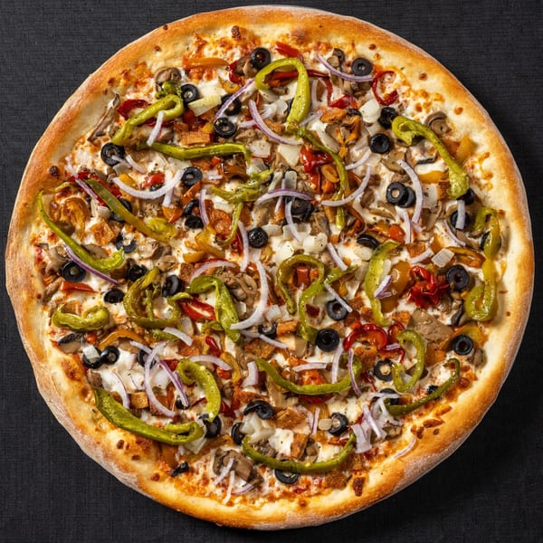 Vinnie's Pizzeria's pizza, topped with green peppers, black olives, onions, mushrooms, and chicken.