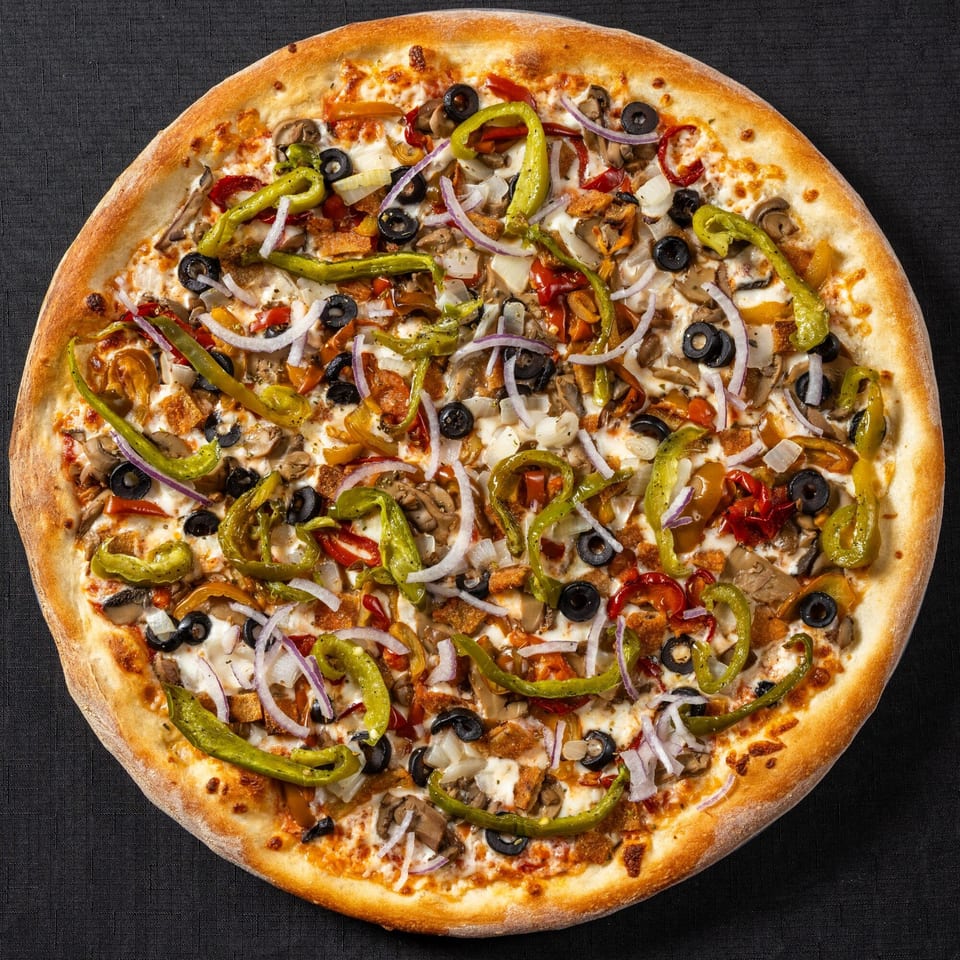 Vinnie's Pizzeria's pizza, topped with green peppers, black olives, onions, mushrooms, and chicken.