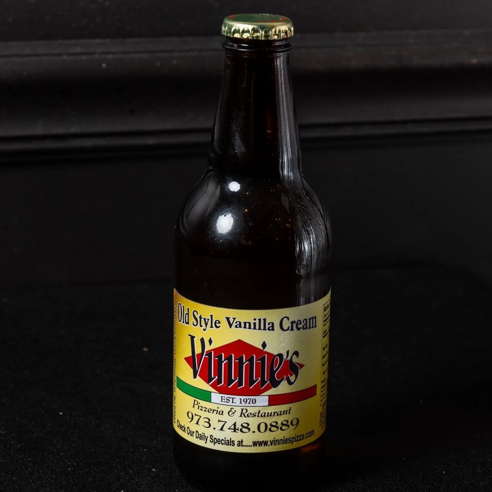 A bottle of Vinnie's Old Style Vanilla Cream soda with a yellow and red label.